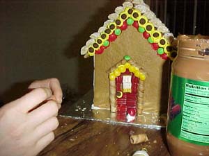 Anne is working on Janine's house. Notice the new kind of peanut butter - Chocolate Silk Sensations. Yummy!! and great glue!