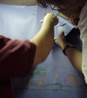 After unloading at the church, we helped Kim Amor put up the backdrops she drew. They added the finishing touch.