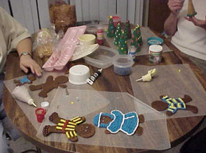 Here we are working at the icing table. Sugar cones make great trees, as you can see the process beginning on the right. Also, the shepherd boy (also known as the little drummer boy as you'll see in later pictures) is getting his blue garment.